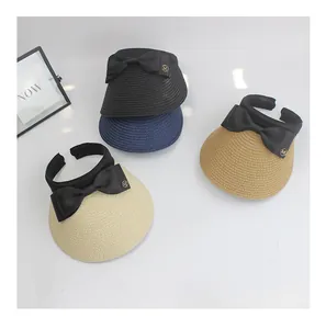 Top view of straw sun visors in four colors with black bows and metal M details