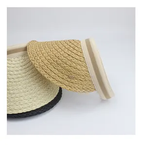 Detail of woven straw sun visors with fine textures and decorative metal branding