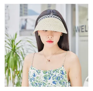 Detail of wide brim straw sun visor with black and white checkered ribbon for women