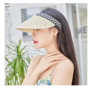 Detail view of woven raffia sun hat with stylish black and white checkerboard headband