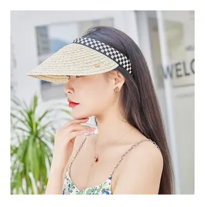 Detail of raffia open top sun hat featuring beige weave and checkerboard ribbon strap