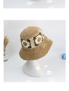 Detail of hand-woven straw sun hat featuring decorative crochet floral patterns