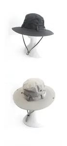 Detail van outdoor zonnehoed met brede rand, metalen oogjes en verstelbare windriem