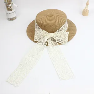 Straw sun hat for women featuring lace bow and ribbons on a minimalist white background