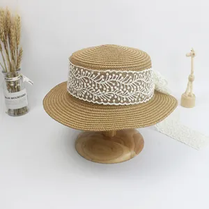 Flat top straw sun hat with wide lace ribbon and bow decoration for beach travel