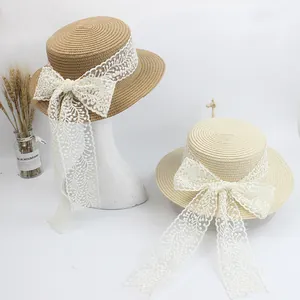 Straw sun hats with large lace bows and ribbons in natural and cream for beach trips