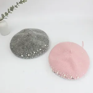Close-up of wool berets with elegant white pearls and rhinestones in pink and gray colors
