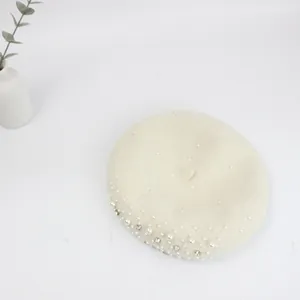 Top view of cream wool beret with elegant pearls and sparkling rhinestones detailing