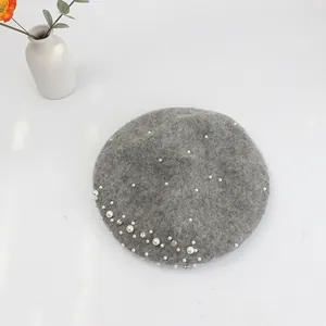 Detailed view of grey wool beret featuring elegant pearls and sparkling rhinestones