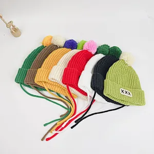 Flat lay of knit beanies with pom-poms and tie straps in eight vibrant candy colors