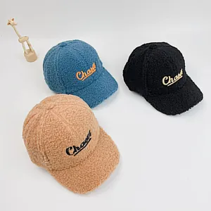 Détail de trois casquettes de baseball en polaire pour enfants en bleu, noir et marron