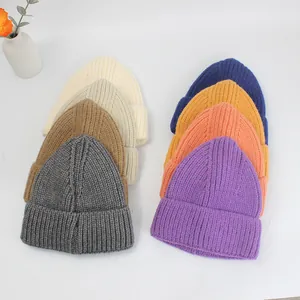Vista piatta di berretti in maglia a coste in vari colori tra cui grigio e beige