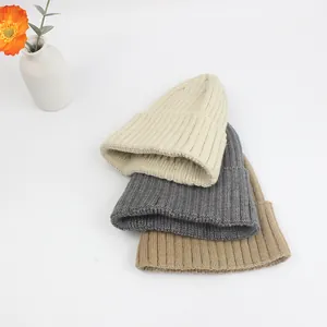 Dicke gerippte Strickmützen im Set in Beige, Grau und Braun für den Winter auf Weiß