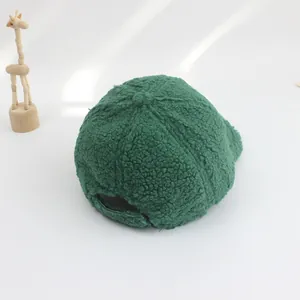 Detailed close-up of dark green sherpa fleece baseball cap for kids with soft texture