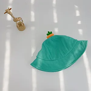 Detail einer minzgrünen Baby-Strickmütze mit süßem Karotten-Akzent und Netzstruktur