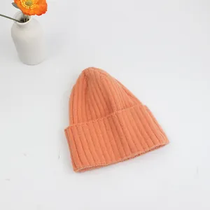 Detailansicht der orangefarbenen Strickmütze mit vertikalem Rippenmuster und Umschlag