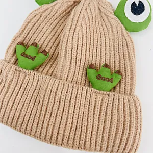 Detailansicht der khakifarbene Kinder-Strickmütze mit Froschaugen und Stickerei