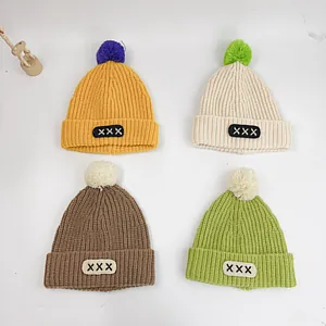 Kids warm knitted beanie hats with large pom-poms in four candy colors for winter