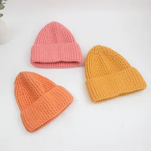 Texture détaillée de bonnets en tricot épais en rose, orange et jaune pour l'hiver