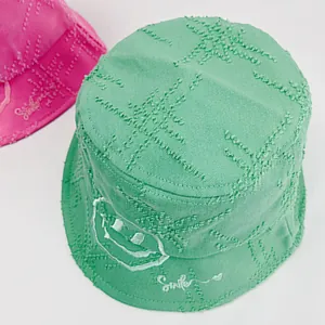 Mint green cotton bucket hat for kids with smiley face embroidery and frayed edges