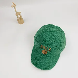 Detailaufnahme der grünen Fleece-Baseballkappe mit gesticktem Smiley und SMILE-Schriftzug