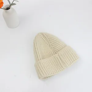 Dettaglio della trama in maglia a coste spessa di un berretto invernale beige da donna