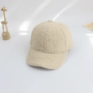 Close-up of a cream-colored fuzzy lamb wool baseball cap with soft minimalist decor