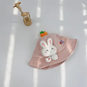 Detail eines rosa Baby-Sonnenhuts mit Plüschhasen-Patch, Karotten-Anhänger und Stickerei