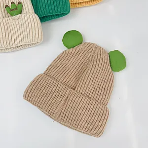 Details der Stricktextur von khakifarbenen und beige Wintermützen mit niedlichen Ohren
