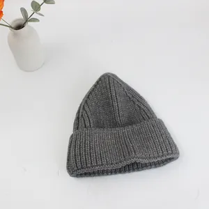 Dettaglio del berretto in maglia grigio scuro con trama a coste e morbida lana calda