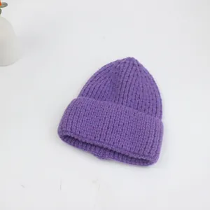 Gros plan détaillé du bonnet en maille épaisse violette avec bordure roulée