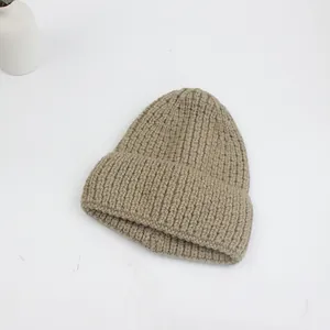 Gros plan détaillé du bonnet en maille côtelée kaki montrant la texture épaisse et les coutures