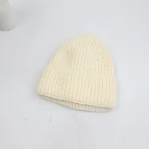 Vue détaillée du bonnet en maille crème avec texture côtelée et bord replié large