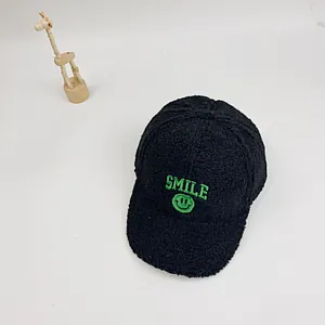 Nahaufnahme der schwarzen Sherpa-Fleece-Kappe mit grüner SMILE-Stickerei und Smiley-Emoji