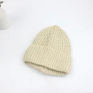 Gros plan sur la maille épaisse beige et le revers de ce bonnet d'hiver chaud