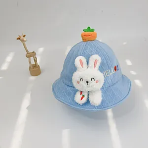 Detail eines blauen Strick-Babyhutes mit Plüschhase, Karotte und Hello-Stickerei