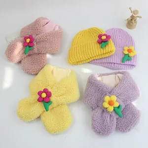 Nahaufnahme von Plüschschals und Strickmützen mit bunten 3D-Blumendekorationen für Kinder