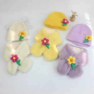 Draufsicht auf bunte Kinder-Strickmützen und Plüschschals mit 3D-Blumendekor
