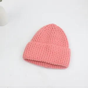 Gros plan détaillé du bonnet en maille rose épaisse avec revers classique et texture