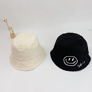 Detail of frayed edge canvas bucket hats with star stitching and smile embroidery