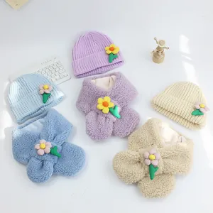 Detailansicht von drei bonbonfarbenen Strickmützen und Plüschschals mit 3D-Blumenakzenten