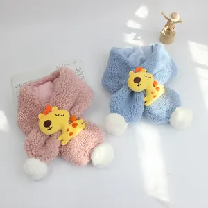 Dettaglio sciarpa in lana d'agnello per bambini con giraffa gialla e pompon bianchi