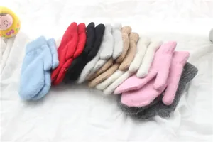 Stapel bunter Strickhandschuhe in verschiedenen Pastell- und Winterfarbtönen