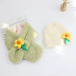 Detail von hellgrünem Fleecheschal und cremefarbener Strickmütze mit gelben Blumen