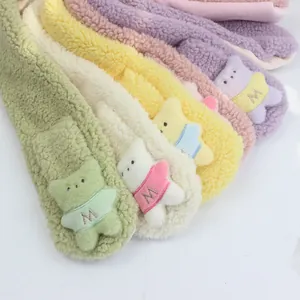 Gros plan d'écharpes en peluche colorées avec broderie lettre M et écussons mignons