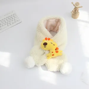 Dettaglio dello scaldacollo in peluche crema per bambini con giraffa e morbidi pompon