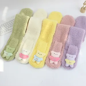 Détail d'écharpes en polaire pelucheuse avec oursons en plusieurs couleurs pastel
