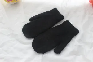 Schwarze Strickfäustlinge mit Rippbündchen flach liegend auf weißem Stoffgrund