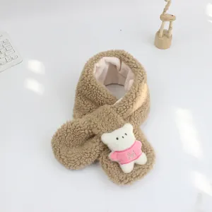 Détail de l'écharpe en peluche camel avec ours 3D en pull rose et logo avec la lettre M