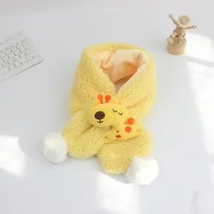 Dettaglio sciarpa di peluche gialla per bambini con giraffa e pompon bianchi